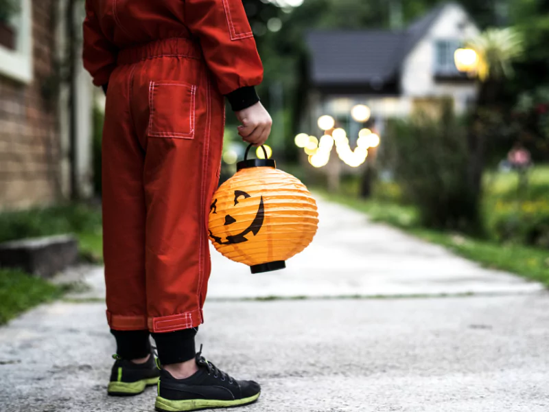 Creative student council ideas for Halloween events featuring a child with a festive lantern.
