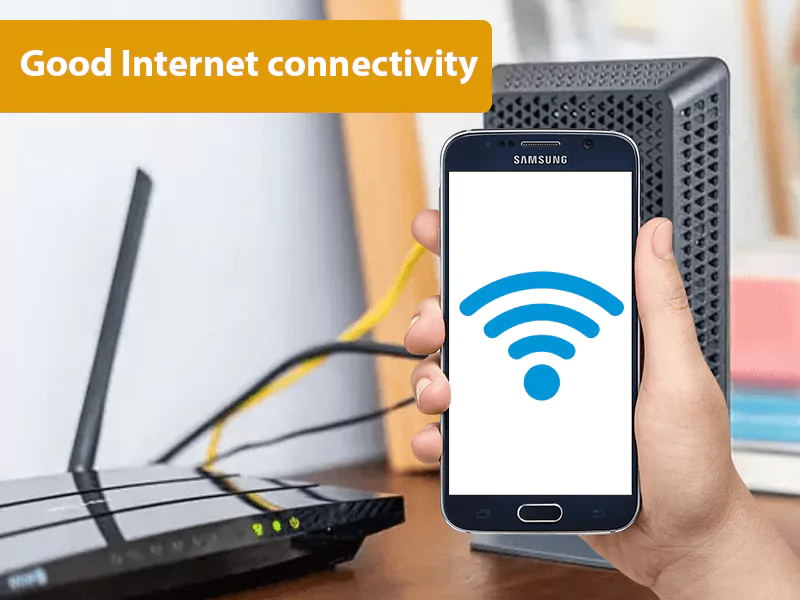 The image shows a hand holding a samsung phone showing WiFi connection and an internet router The image shows a hand holding a samsung phone showing WiFi connection and an internet router